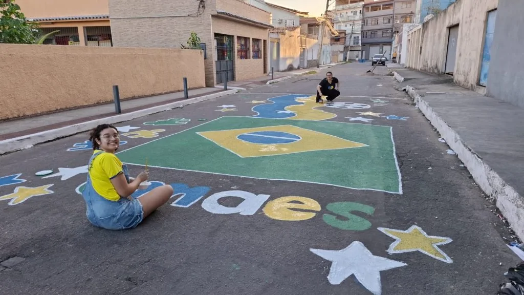 Jovens atendidos pela Amaes pintam rua em Vila Velha inspirados pela Copa do Mundo
