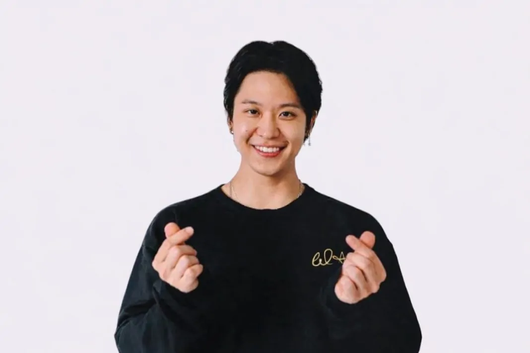 Cantor de BTS fazendo corações com os dedos