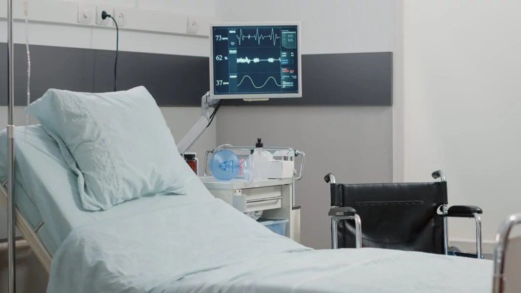 Empty hospital ward with heart rate monitor and bed