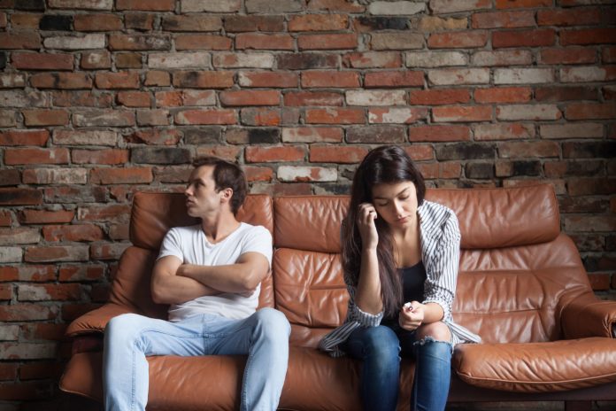 Marido e mulher sentados distantes durante uma crise no casamento