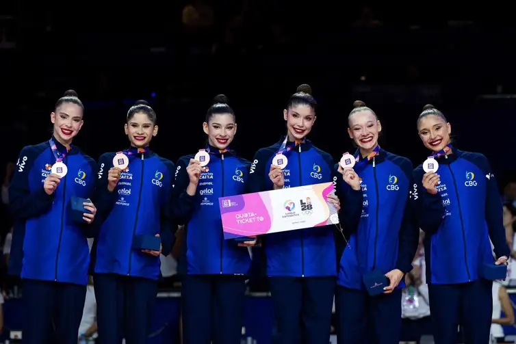 Grupo de ginástica ritmica com medalhas de brpnze e prêmio na mão