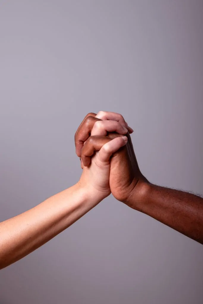 Mãos de pessoas diferentes reunidas em sinal de diálogo, apoio e dignidade (Feminismo e cristianismo podem caminhar juntos?)