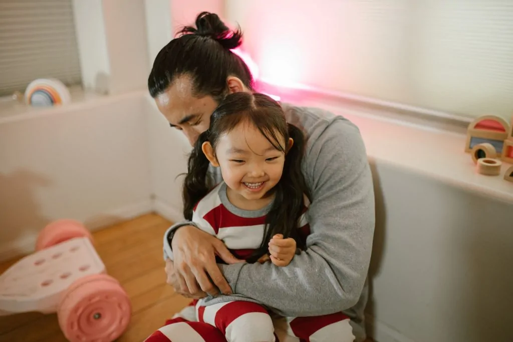 Pai e filha se abraçam demonstrando afeto e presença paterna