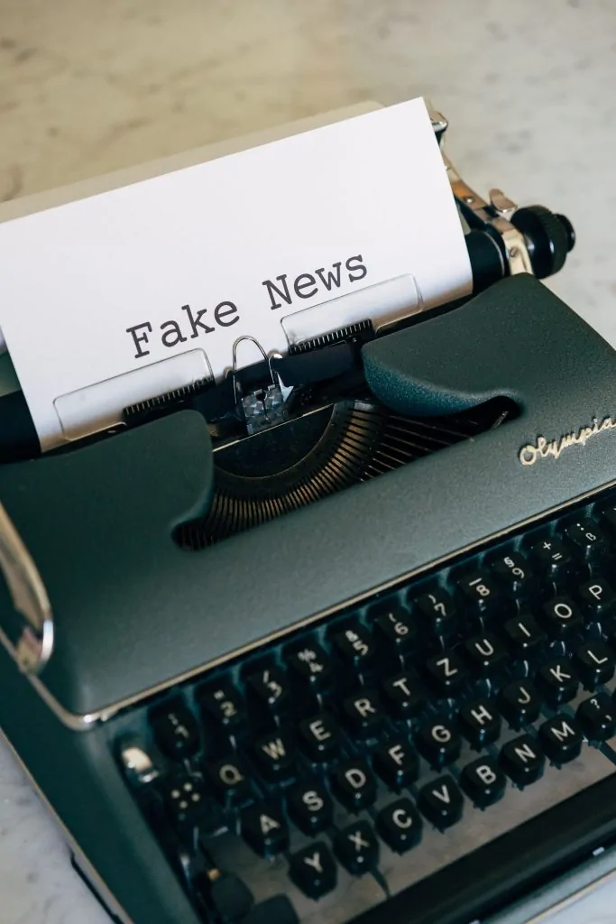 Máquina de escrever antiga com uma folha contendo a expressão “Fake News”