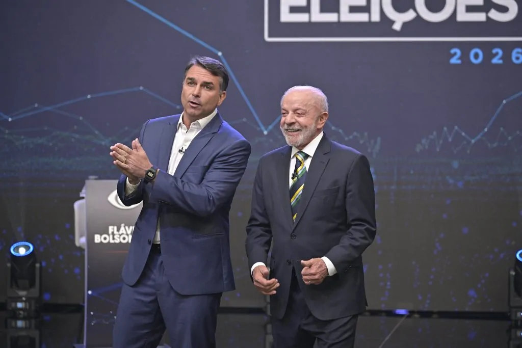Flávio Bolsonaro fala e gesticula com os braços durante o debate da Band.